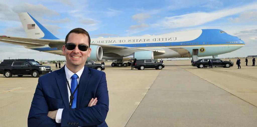 Heath Montgomery, '05, smiles in front of an aircraft.