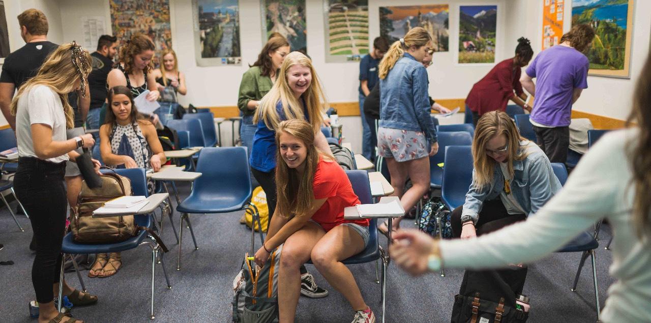 Students smile as they settle into their desks.